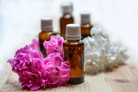 Ätherisches Öl für Aromatherapie in brauner Flasche mit Blumen aussenrum