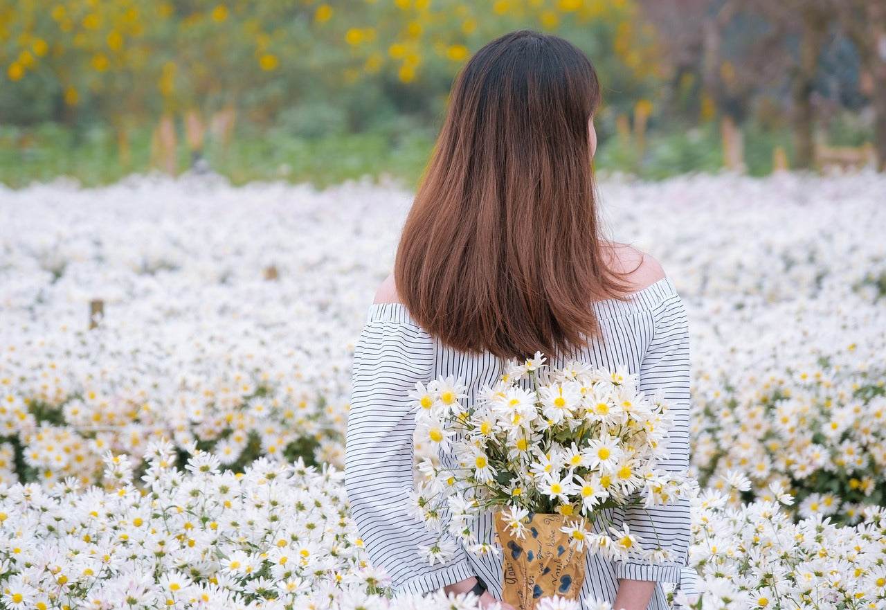 Frau mit Blumen hinter dem Rücken