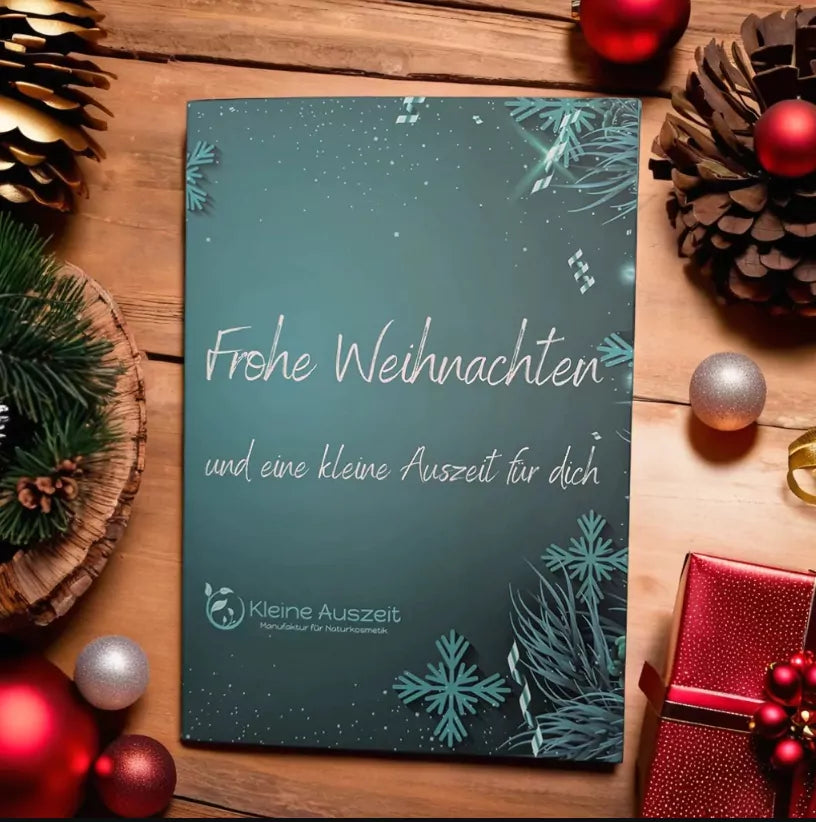 Adventskalender mit 24 Seifenträume Petrolfarben mit Aufschrift : Frohe Weihnachten und eine kleine Auszeit für dich. Ebenso sieht man Zapfen und rote Weihnachtskugeln alles  hübsch dekoriert mit roter Geschenkverpackung.