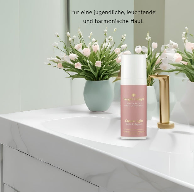 Nahaufnahme eines Waschbeckens aus weißem Marmor. Darauf steht eine rosafarbene Produktflasche mit dem Etikett Relight Delight - Cream light. Rechts daneben befindet sich ein goldener Wasserhahn. Links steht eine türkisfarbene Vase mit rosafarbenen und weißen Blumen. Im oberen Teil des Bildes ist der Text „Für eine jugendliche, leuchtende und harmonische Haut“ zu sehen.