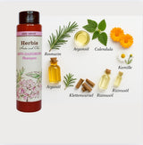 Alt-Text: "Kreisförmige Anordnung natürlicher Inhaltsstoffe des HERBIS Anti Schuppen Shampoos. In Bild und Schrift :Rosmarin, Argan, Calendula, Kamille, Rizinusöl, Klettenwurzel und Arganöl daneben eine Shampooflasche