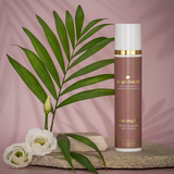 Edler Pumpspender in Altrosa mit goldener und weißer Aufschrift: Metamorphose Wirkstoffosmetik - Cleansing Milk 100ml Transformation die man sieht und fühlt - Relight Delight Auf Basis Kaltgepresster Bio-Wirköle. Daneben weiße Rosenköpfe, ein Palmblatt. Alle Produkte stehen auf einem hellen, flachen Stein.