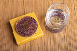 Orgon Untersetzer Amethyst als Unterlage für ein Trinkglas
