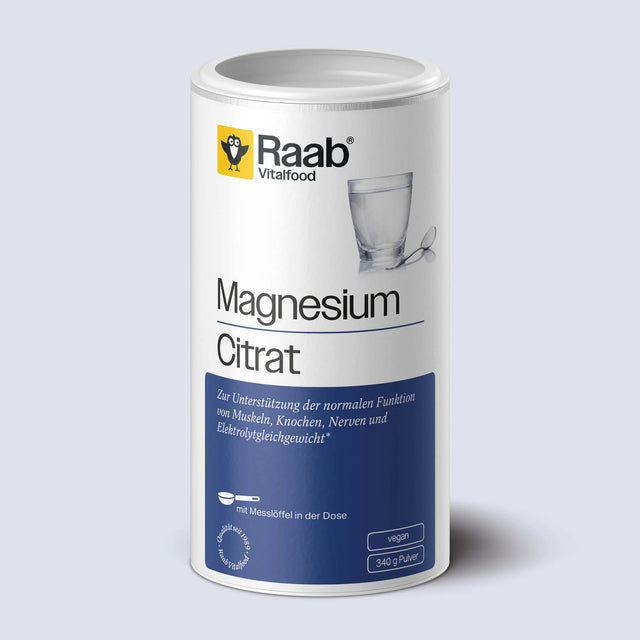 Weiße Dose mit weiß-blauem Etikett von Raab Vitalfood Magnesiumcitrat Pulver, daneben ein Glas Wasser mit Teelöffel – Nahrungsergänzungsmittel, vegan, gut löslich