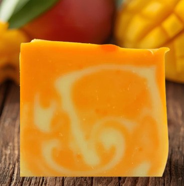 Nahaufnahme von Mango auf Holzuntergrund – und einem Seifenstück 