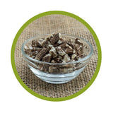 Nahaufnahme einer Glasschale mit naturbelassenen, schonend getrockneten und geschnittenen Bio-Löwenzahnwurzeln auf Jute-Untergrund mit grünem Kreis-Rahmen.