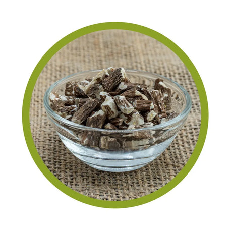 Nahaufnahme einer Glasschale mit naturbelassenen, schonend getrockneten und geschnittenen Bio-Löwenzahnwurzeln auf Jute-Untergrund mit grünem Kreis-Rahmen.