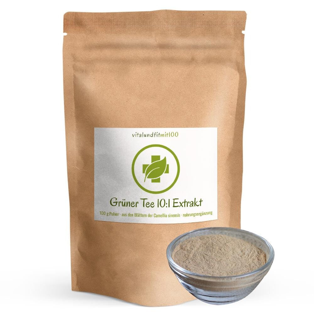 Stehender brauner Papiertüte von Grüner Tee 10:1 Extrakt von vitalundfitmit100 mit einer gefüllten Glasschale mit braunem Tee-Extraktpulver davor.