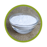 Kleine Schale aus Glas, gefüllt mit feinem, weißem Nicotinsäure-Pulver (Niacin), platziert auf einem Jute-Untergrund mit grünem Kreis-Rahmen.