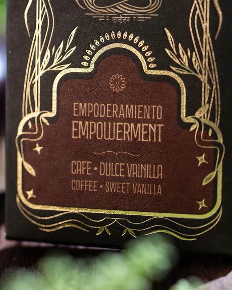 Nahaufnahme der Verpackungsunterseite mit den Aufschriften Empoderamiento, Empowerment, Cafe - Dulce Vainilla und Coffee - Sweet Vanilla in goldener Verziehrung.