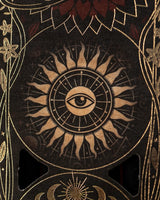 Nahaufnahme des Verpackungsmotivs mit einem zentrierten Auge in einem flammenden Sonnenrad mit goldenen Strahlen und Ornamenten.