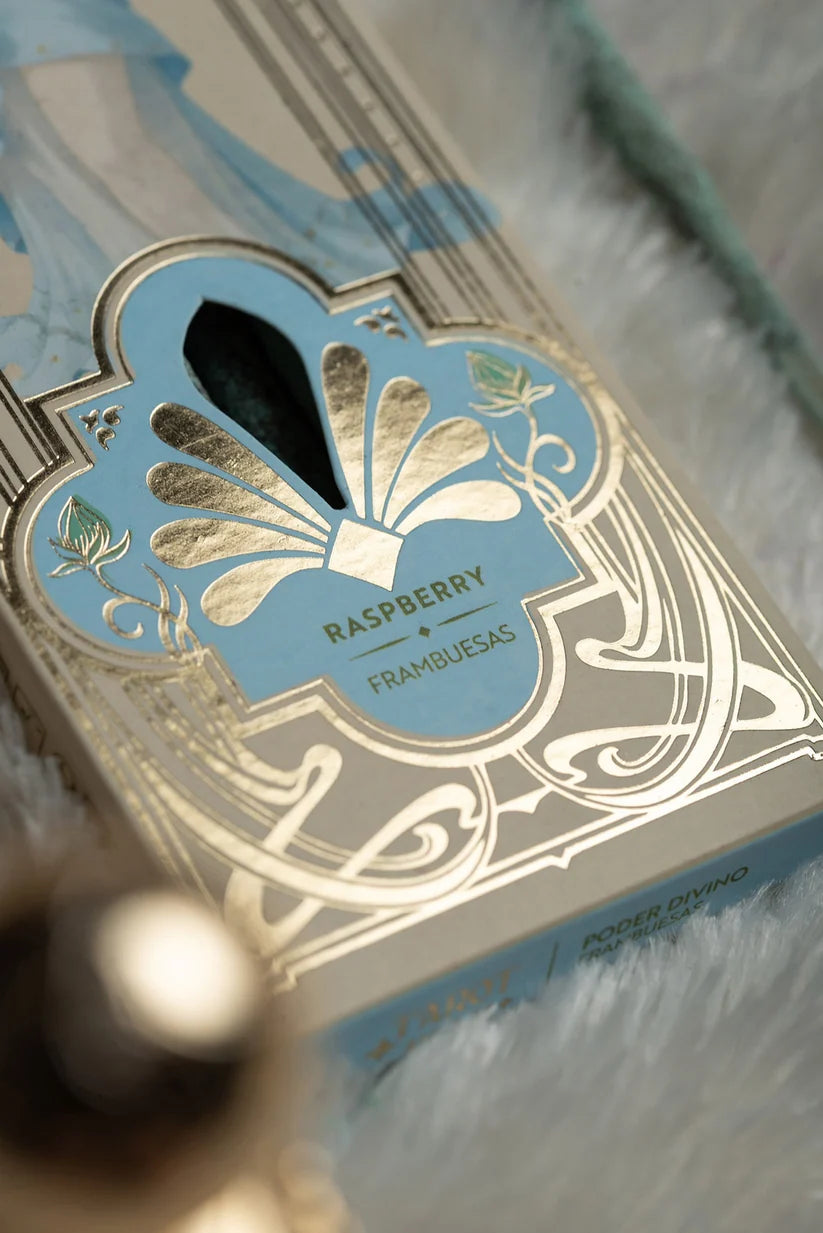 Nahaufnahme der Unterseite der Verpackung mit goldenem Ornament-Muster, Sichtfenster für die hellblauen Stäbchen und der Duftbezeichnung Raspberry / Frambuesas
