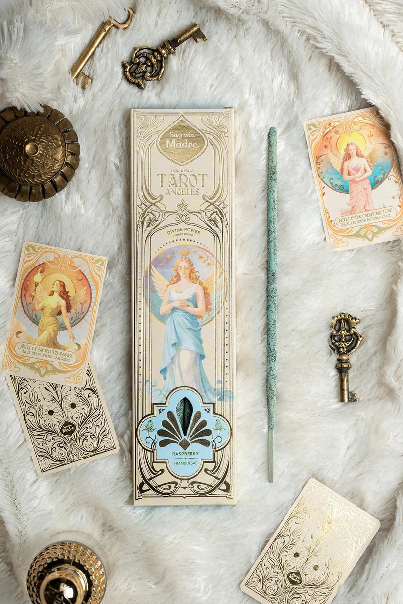 Arrangement des Sagrada Madre Tarot Angels Räucherwerks auf weißem Fell mit Verpackung, hellblauem Stäbchen, zwei Engelkarten und antik aussehenden Messingschlüsseln