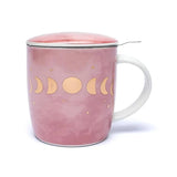 Rosa Teetasse mit Deckel und einem goldenen Mondphasen-Muster. Ein Metallsieb mit Griff ist in die Tasse eingesetzt, um losen Tee zuzubereiten. Der Tassenkörper hat einen subtilen Farbübergang, der an Marmor oder Aquarell erinnert.