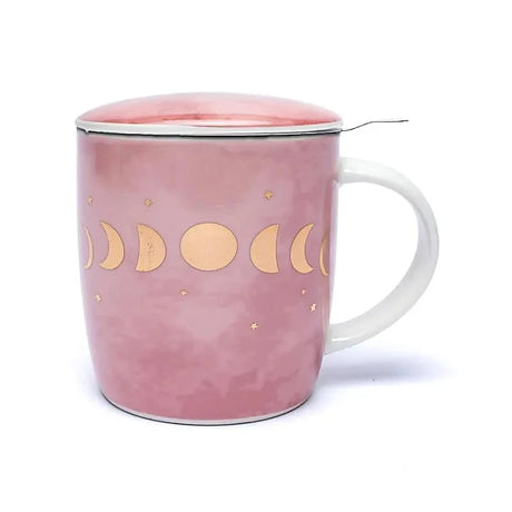 Rosa Teetasse mit Deckel und einem goldenen Mondphasen-Muster. Ein Metallsieb mit Griff ist in die Tasse eingesetzt, um losen Tee zuzubereiten. Der Tassenkörper hat einen subtilen Farbübergang, der an Marmor oder Aquarell erinnert.